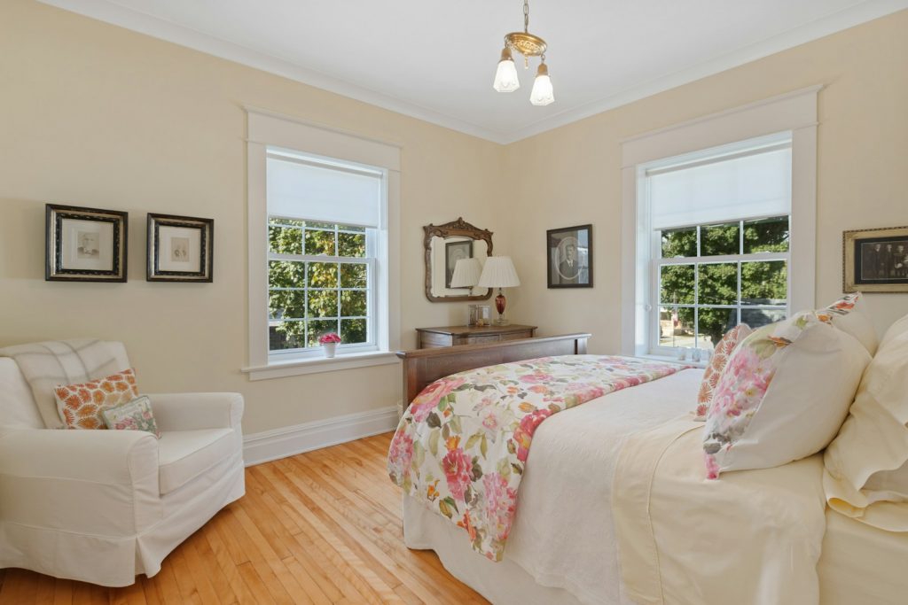 a bed room with a neatly made bed and a chair